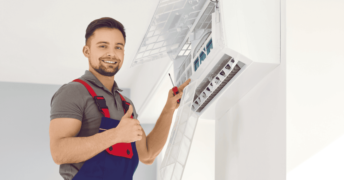 A handyman inspecting an air conditioning unit