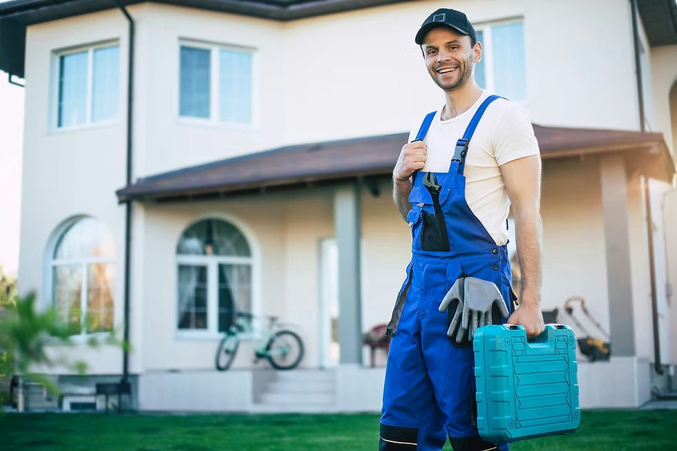 a man wearing overalls and holding a drill case standing in front of a home