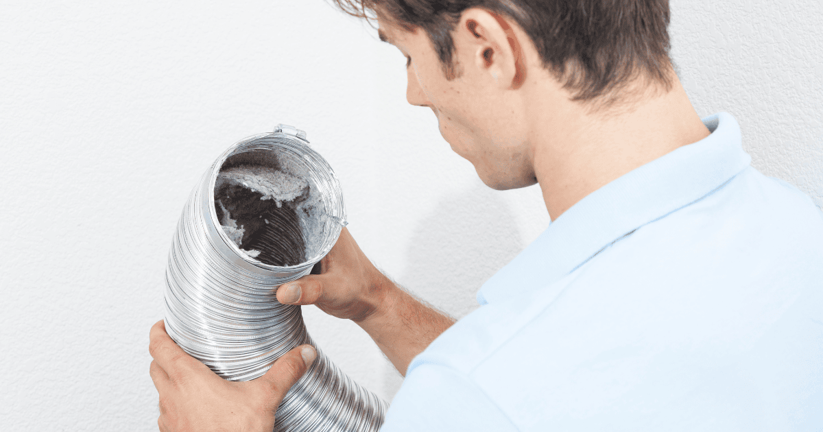 man looking into a dryer vent hose