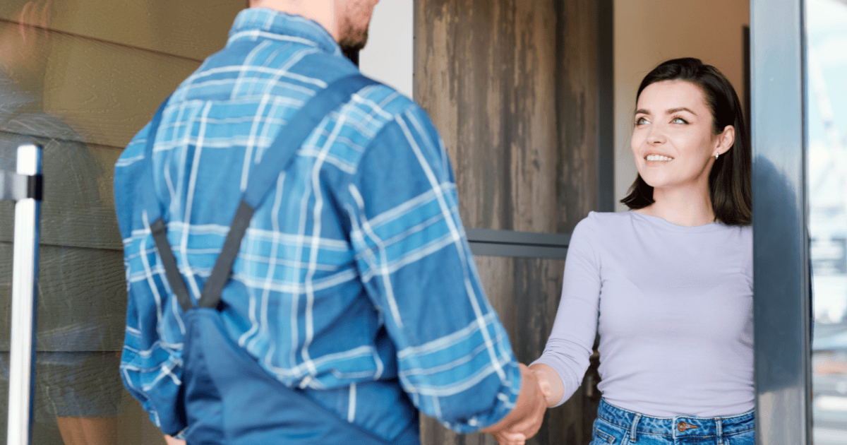 a woman shaking the hand of a handyman at her front door